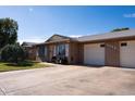 A quaint brick home featuring a driveway, a well-manicured front yard and a two-car garage at 9602 W Ironwood Dr # A, Peoria, AZ 85345