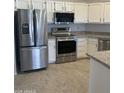 Modern kitchen with stainless steel appliances, white cabinets, and granite countertops at , Mesa, AZ 85205