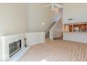 Open living room with fireplace, high ceilings, hardwood floors, open to kitchen, and stairway to the second floor at 100 E Fillmore St # 227, Phoenix, AZ 85004