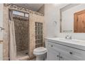 Bathroom featuring stone-tiled shower with glass block window and modern vanity at 1110 E Utopia Rd, Phoenix, AZ 85024