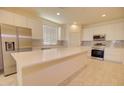Modern kitchen features stainless steel appliances, a large center island, and sleek white cabinetry at 1130 E Westwood Dr, Casa Grande, AZ 85122