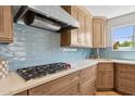 Modern kitchen with stainless steel appliances, cooktop, quartz countertop, and blue tile backsplash at 14802 N 3Rd Ave, Phoenix, AZ 85023