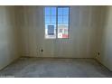A bedroom under construction featuring unfinished concrete floors and natural light from a window at 15792 W Beryl Ave, Waddell, AZ 85355
