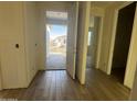 Bright foyer with wood-look tile flooring, neutral walls, and an open doorway, leading to a room with a window at 15792 W Beryl Ave, Waddell, AZ 85355