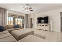 Bright living room featuring a sectional sofa, ceiling fan, and sliding door to the backyard at 19834 N Tammy St, Maricopa, AZ 85138