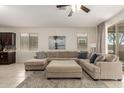 Comfortable living room with tile flooring, large sectional sofa, and view of backyard at 19834 N Tammy St, Maricopa, AZ 85138