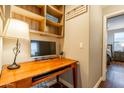 Cozy home office nook with a built-in desk, overhead shelving, and an adjacent bedroom at 20100 N 78Th Pl # 3126, Scottsdale, AZ 85255
