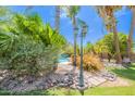 Serene backyard landscaping with stone accents, mature trees, and a glimpse of the inviting pool area at 2160 E Kenwood St, Mesa, AZ 85213