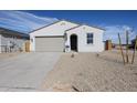 Charming single-story home featuring a desert-style gravel yard, a two-car garage and a welcoming arched entryway at 22085 N Rummler Ln, Maricopa, AZ 85138