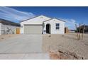 Charming single-story home featuring a desert-style gravel yard, a two-car garage and a welcoming arched entryway at 22085 N Rummler Ln, Maricopa, AZ 85138