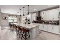 Gourmet kitchen with white cabinets, stainless steel appliances, granite countertops, and large center island with seating at 2229 N 139Th Dr, Goodyear, AZ 85395