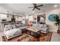 Bright open concept featuring the living room with a ceiling fan connected to the gourmet kitchen with a large kitchen island at 2229 N 139Th Dr, Goodyear, AZ 85395