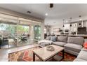 Open-concept living room with sliding glass doors to patio, neutral tones, and seamless connection to the kitchen and dining area at 2229 N 139Th Dr, Goodyear, AZ 85395