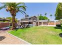 Spacious backyard featuring lush green grass, a hot tub, and mature palm trees, creating a serene outdoor retreat at 3377 W Grandview Rd, Phoenix, AZ 85053