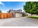Exterior of a home with a large driveway, wooden gate, and well-maintained landscaping at 3377 W Grandview Rd, Phoenix, AZ 85053