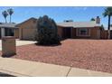 Inviting single-story home with brick accents, a well manicured yard and a two car garage at 3779 E Sweetwater Ave, Phoenix, AZ 85032