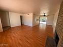 Spacious living room with wood floors and a brick fireplace, perfect for entertaining at 3779 E Sweetwater Ave, Phoenix, AZ 85032