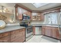 Stylish kitchen with stainless appliances, dark wood cabinets, and tile flooring offers a modern cooking space at 3830 E Lakewood Pkwy # 1051, Phoenix, AZ 85048