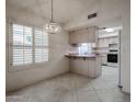 Bright kitchen with tile floors, ample storage, and a charming light fixture at 3833 W Rene Dr, Chandler, AZ 85226