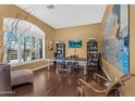 Bright bonus room featuring wood floors, a ping pong table, built-in shelves, and a large arched window at 41908 N Harbour Town Ct, Anthem, AZ 85086