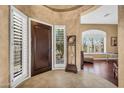 Elegant foyer with tile flooring, a decorative clock, and large windows with plantation shutters at 41908 N Harbour Town Ct, Anthem, AZ 85086