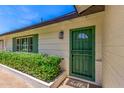 Inviting entryway featuring a secure, decorative green door and lush greenery at 506 W Seldon Ln, Phoenix, AZ 85021