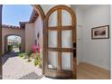 Charming front door with decorative glass and a view of the lush desert landscape beyond at 8974 E Rusty Spur Pl, Scottsdale, AZ 85255