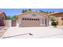 A one story home with a beige garage door, desert landscaping, and a terracotta tile roof at 10952 S Desert Lake Dr, Goodyear, AZ 85338