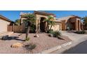Inviting tan two-story home featuring desert landscaping and a tile roof at 1227 E Sheena Dr, Phoenix, AZ 85022