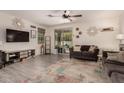 Comfortable living room with neutral decor, a ceiling fan, and sliding glass door access to the backyard at 12565 W Palmaire Ave, Glendale, AZ 85307