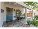 Charming covered porch with a unique front door, potted plants, and a tiled walkway leading to the entrance at 1306 W Heatherbrae Dr, Phoenix, AZ 85013