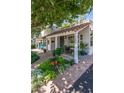Quaint home with a tile roof, front porch, and vibrant flower beds, offering a cozy and inviting atmosphere at 1306 W Heatherbrae Dr, Phoenix, AZ 85013