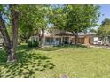 Inviting home with lush green lawn, mature trees, and a classic tile roof, creating a serene curb appeal at 1306 W Heatherbrae Dr, Phoenix, AZ 85013