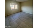 Bedroom featuring neutral walls, tile flooring, and a large window at 1352 S 221St Ln, Buckeye, AZ 85326