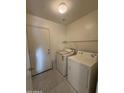 Practical laundry area with washer, dryer, and storage shelving at 1352 S 221St Ln, Buckeye, AZ 85326