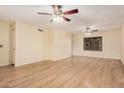 Bright and spacious living room featuring laminate floors, neutral walls, and modern ceiling fans at 14402 N 58Th Dr, Glendale, AZ 85306