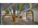 Inviting front porch with brick pavers, mature trees, and an arched entryway to the home at 1615 E Fremont Dr, Tempe, AZ 85282