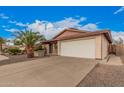 A single-story home has a two-car garage and a large driveway with desert landscaping at 1857 S El Marino Cir, Mesa, AZ 85202