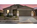 Attractive single Gathering home with a two-car garage and desert landscaping in twilight at 20319 N 224Th Dr, Surprise, AZ 85387