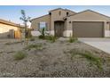 Charming home featuring a two-car garage and low maintenance desert landscaping at 20319 N 224Th Dr, Surprise, AZ 85387