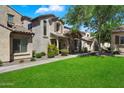 Beautiful two-story home featuring well-manicured lawn, stone details, and neutral color palette at 26678 N Babbling Brook Dr, Phoenix, AZ 85083