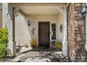 Inviting front porch features decorative details, neutral colors, and stylish exterior lighting at 26678 N Babbling Brook Dr, Phoenix, AZ 85083