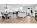 Open-concept living and dining area with wood flooring, island seating and plentiful natural light at 2924 W Anderson Dr, Phoenix, AZ 85053