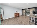 Room with engineered wood floors, barn-door closet, piano, mirror, and modern office setup at 2924 W Anderson Dr, Phoenix, AZ 85053
