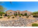 Well-maintained single-story home showcasing desert landscaping and a decorative stone dry river at 4633 E Chaparosa Way, Cave Creek, AZ 85331
