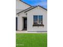 Close up of house with large window with flower box and lush green lawn at 486 E Bamboo Ln, San Tan Valley, AZ 85140