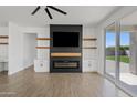 Modern living room with sleek fireplace, wood-look floors, and sliding glass doors to the backyard at 486 E Bamboo Ln, San Tan Valley, AZ 85140