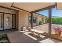 Inviting front porch with brick accents, a concrete bench, and glass front door at 4944 W Vista Ave, Glendale, AZ 85301