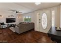 Cozy living room with hardwood floors, a ceiling fan, and a comfortable gray sectional sofa at 4944 W Vista Ave, Glendale, AZ 85301