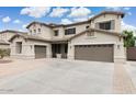 Expansive two-story home featuring a three-car garage and neutral stucco exterior with beautiful landscaping at 614 E Benrich Dr, Gilbert, AZ 85295